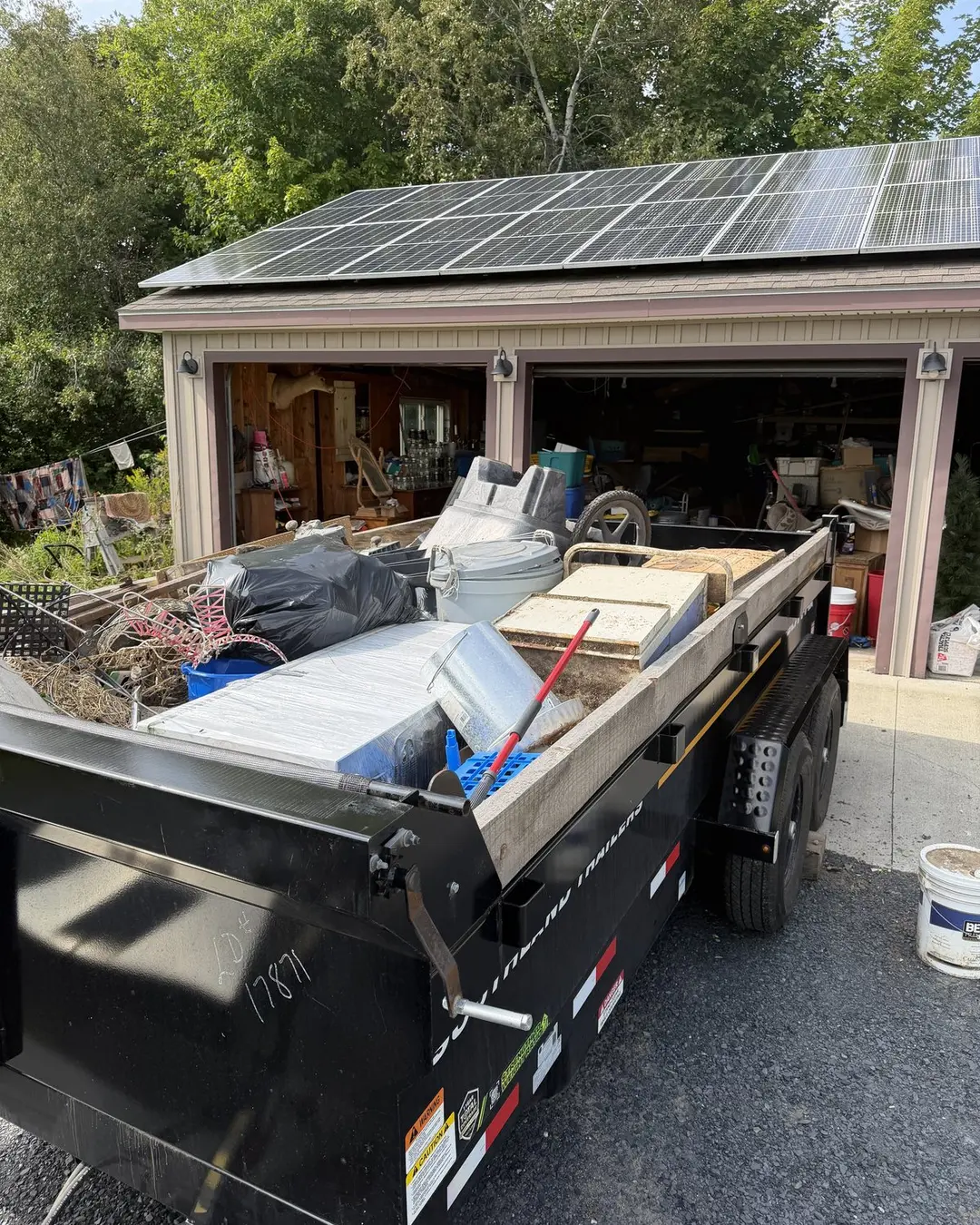 Loaded removal trailer in front of a Maine garage