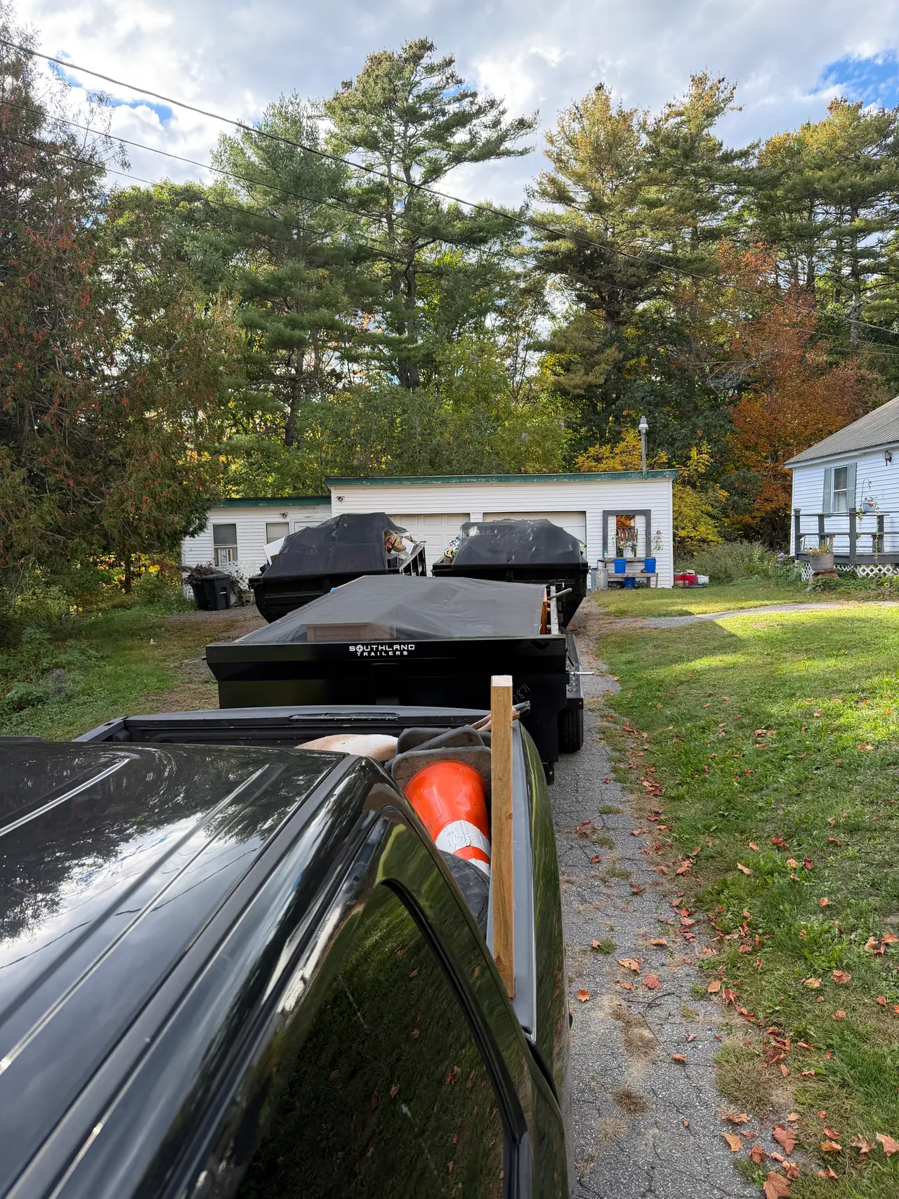 Black removal trailers parked outside a Maine property