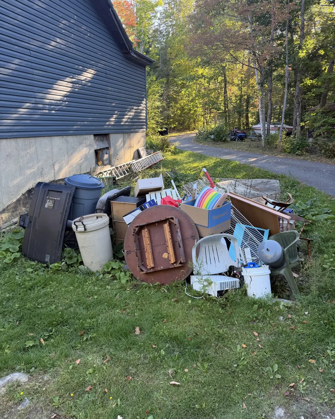 Discarded furniture and household goods beside a home