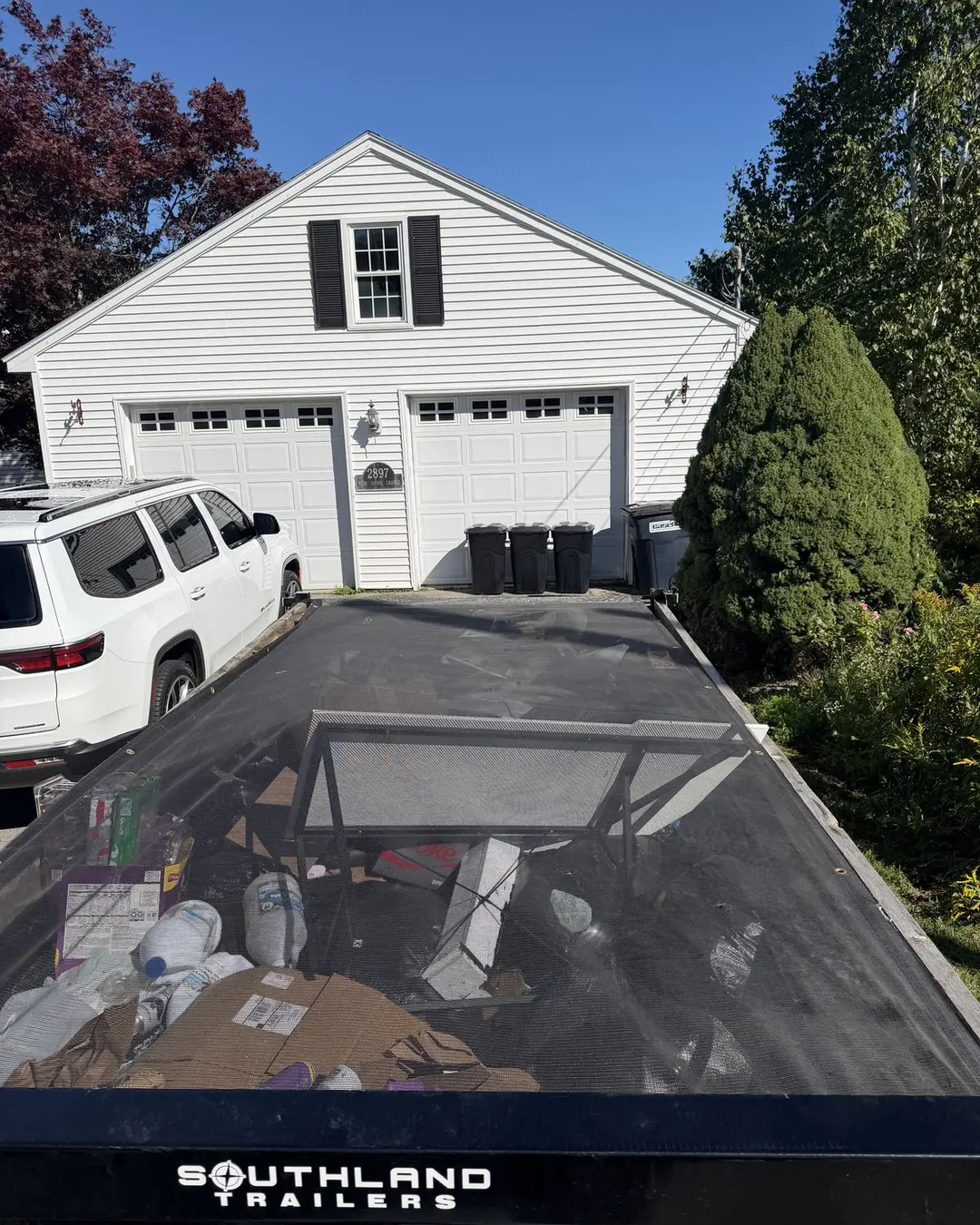 Junk removal trailer parked in front of a home